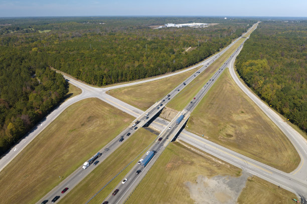 从上面看繁忙的美国高速公路与快速移动的车辆在树林之间。州际运输概念图片下载