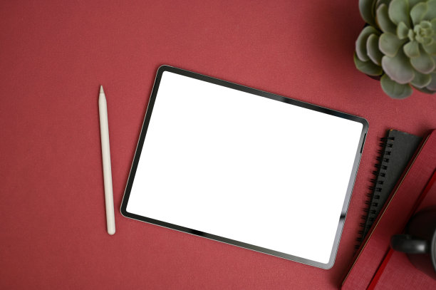 现代工作空间与数字平板电脑模型在红色背景。俯视图图片下载