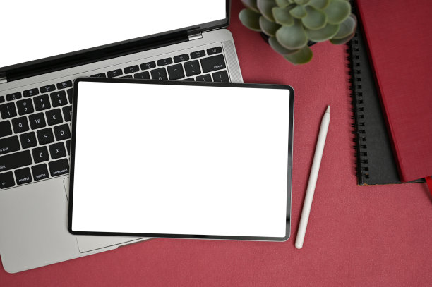 现代创意办公桌面视图与数字平板电脑上的笔记本电脑在红色的桌子上。图片下载