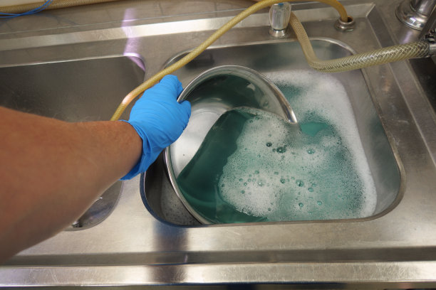 消毒部门正在清洗生理盐水盘图片下载