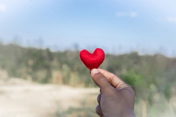 红心在手，自然背景，情人节感觉浪漫。图片下载