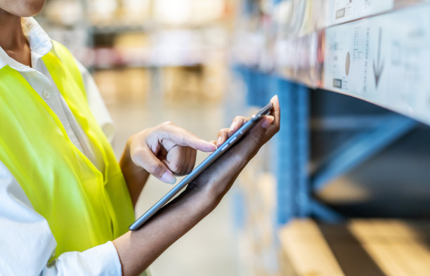 亚洲女经理用数码平板电脑在仓库货架上的纸板箱里进行产品盘点。在工厂验货的女专业助理。图片下载