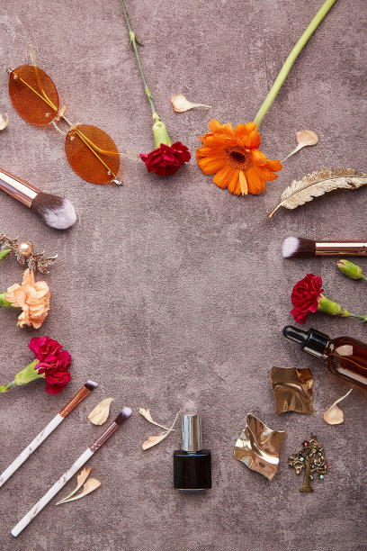 时髦的女性套装，化妆刷、配件、滴管瓶、太阳镜、化妆品和非洲菊花，中间有复制空间图片下载