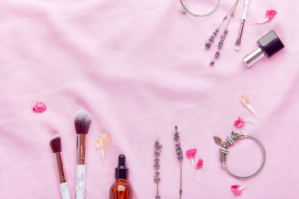 化妆刷、滴管瓶、精华液、女性配饰等在薰衣草间平铺着复制空间图片下载