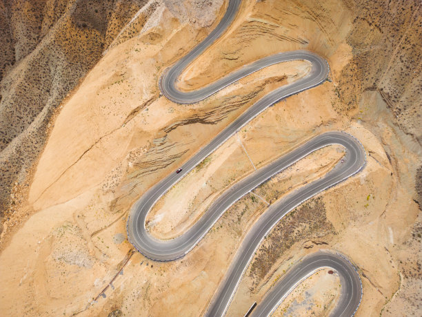 蛇形弯道的鸟瞰图。蜿蜒的山路。从上面看。弯弯曲曲的车道上挤满了汽车图片下载