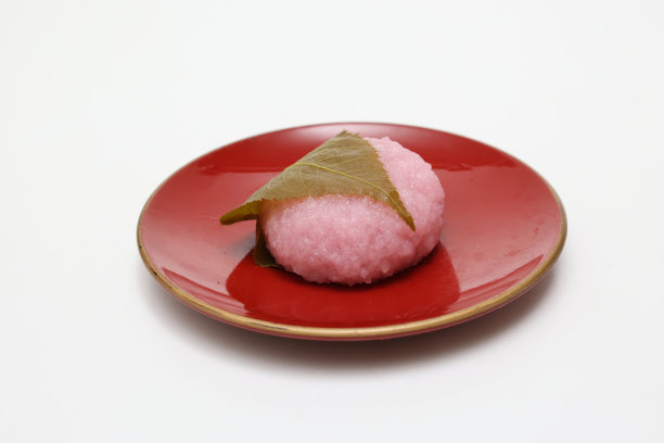 豆沙年糕用樱桃叶包裹，白色背景。图片下载