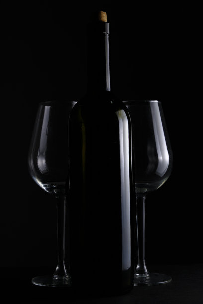 一瓶葡萄酒和两个酒杯黑色背景。图片下载