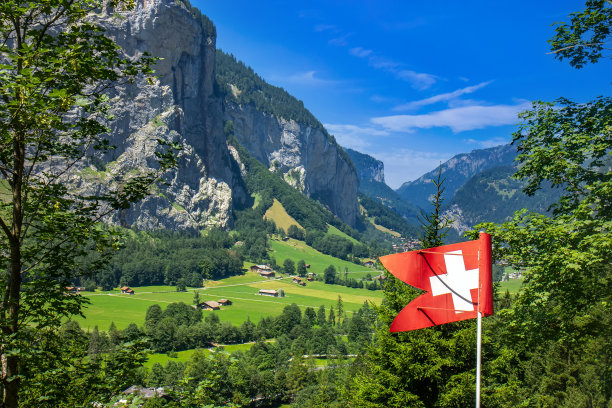 夏季，在瑞士阿尔卑斯山脉上，欣赏带有瑞士国旗的Lauternbrunen山谷图片下载