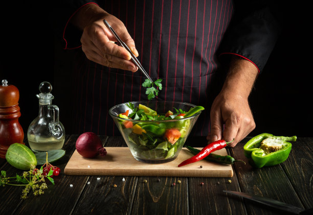 厨师亲手制作的美味蔬菜沙拉。在深色背景上的酒店菜单或食谱的概念图片下载