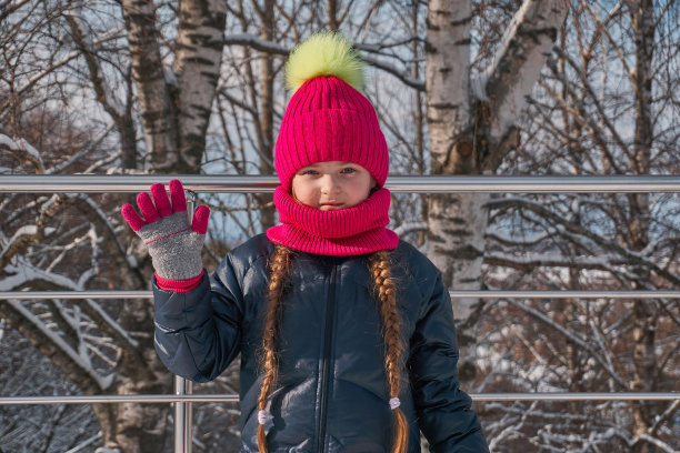 一个穿着暖暖的冬衣，带着西克的女孩挥手致意。红色的鞭子和帽子，上面有一个大大的黄色的南瓜图片下载