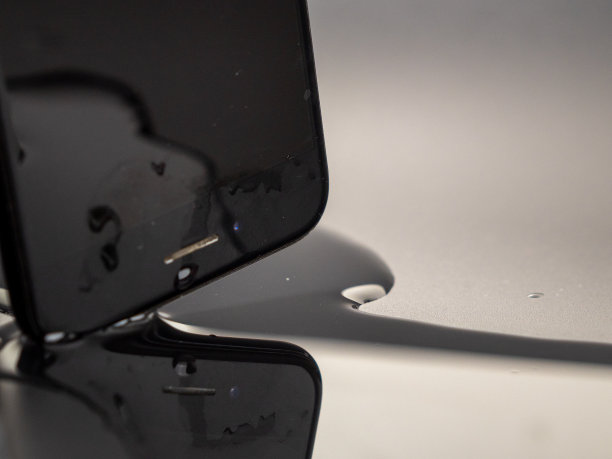 水洒在了智能手机上。智能手机掉进水里了。图片下载