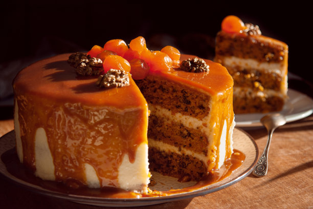 美味的胡萝卜蛋糕，核桃，焦糖软糖和金桔。黑暗的背景。关闭了。图片下载