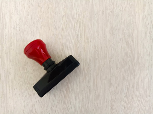 侧视图的红色处理橡胶图章孤立的木材纹理背景图片下载