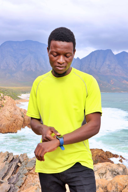 年轻的非洲黑人男子使用手机和智能手表图片下载