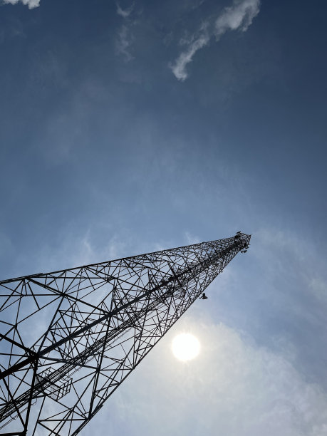 高电信塔台与阳光明媚的蓝天背景图片下载