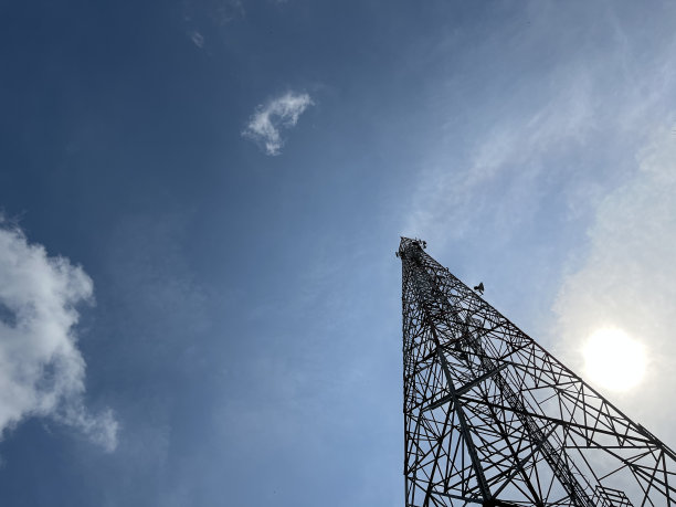 热带城中村地区阳光明媚的蓝天背景下的高电信塔台图片下载