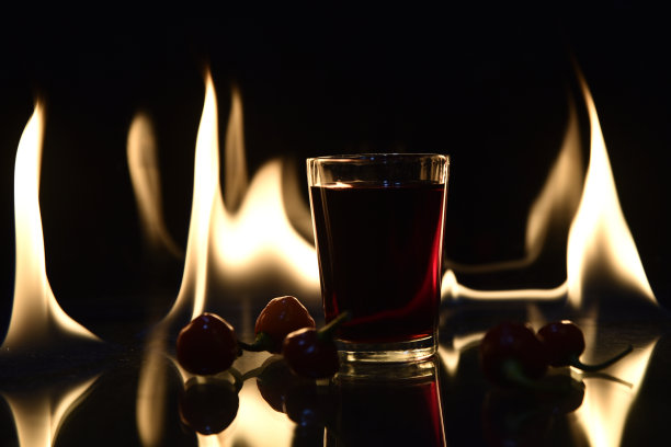 镜头的饮料与火的背景与反射饮料红辣椒热的形象图片下载