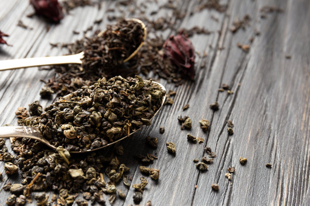 干绿茶和红茶在一个黑暗的背景特写。图片下载