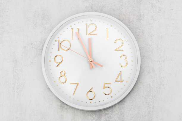 白色的墙上挂着白色的钟。图片下载