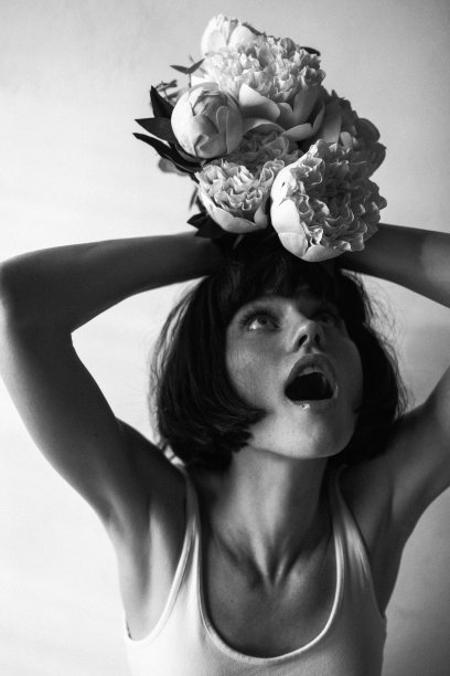 一个感性的女人手持鲜花的照片。黑白电影图片下载