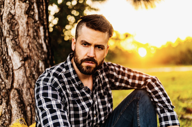 30多岁的英俊大胡子男子在大自然中拍摄了一张严肃的户外肖像图片下载