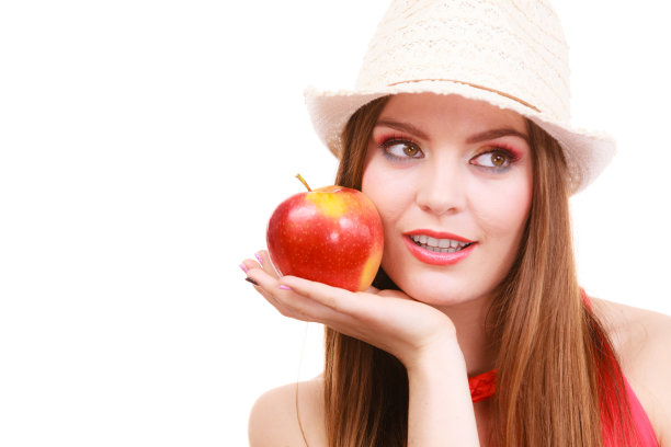 女人夏天戴着彩色的帽子化妆，手持苹果果图片下载