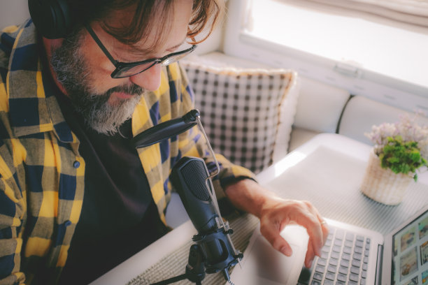 播客商务人士在工作时对着麦克风说话，在一辆露营车里的笔记本电脑上录音，就像数字游牧民一样聪明的工作旅行生活方式。现代人与科技的联系图片下载