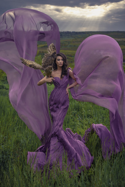 美丽的女人与猫头鹰在紫色的礼服在大自然图片下载