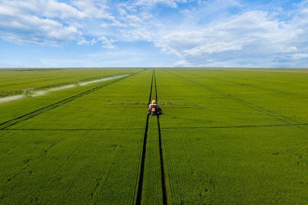拖拉机在绿地上喷洒肥料鸟瞰图。图片下载