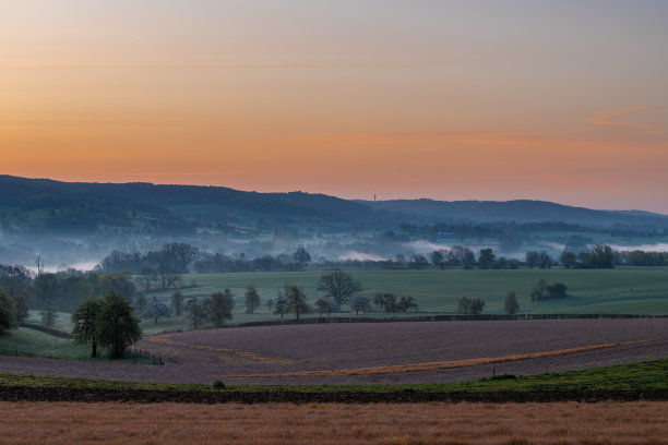 夏日清晨，五彩缤纷的日出，地面上有一点雾，在荷兰林堡的山坡上可以看到壮观的景色图片下载