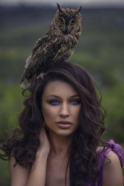 美丽的女人与猫头鹰在紫色的礼服在大自然图片下载