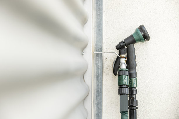 从连接在阳台墙上的软管上取下的水龙头图片下载