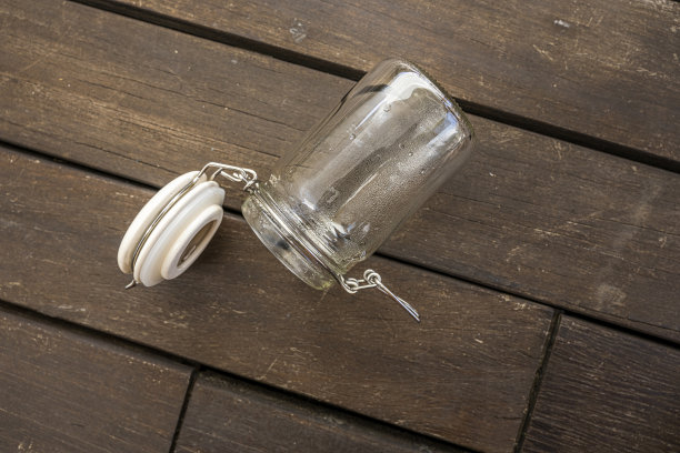 金合欢木板上的空玻璃瓶图片下载