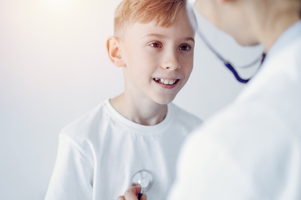 医生和快乐微笑的小男孩病人在诊所例行体检。医学、保健概念图片下载