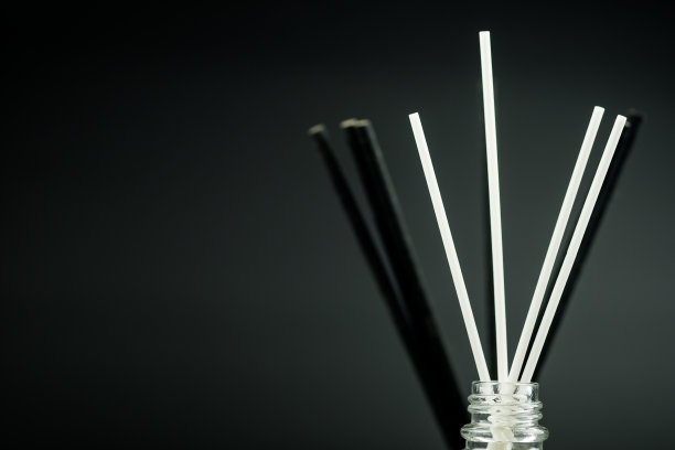 香水扩散器香水清新剂与黑色和白色棒在黑色的背景与空间的文字。图片下载