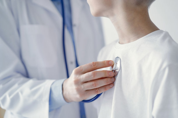 身份不明的医生和接受常规医疗检查的男童病人。医生使用听诊器，近距离观察。医学、保健概念图片下载