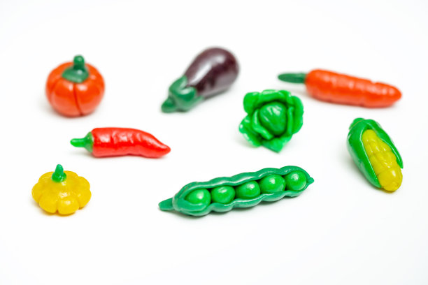 白色背景上色彩鲜艳的橡皮泥蔬菜：玉米、豌豆、茄子、卷心菜、辣椒。创意手工蔬菜。图片下载
