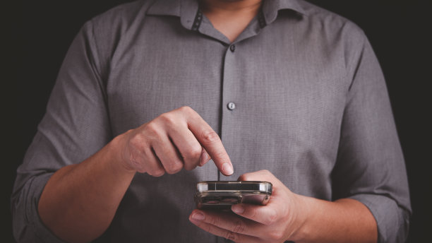 商人手里拿着智能手机，按下智能手机的触摸屏按钮图片下载