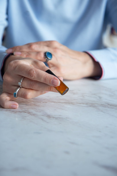 精油玻璃瓶在一个女人的手中图片下载