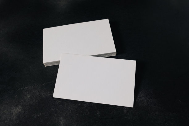 黑色背景上的白色空白名片模型。模拟演示。图片下载