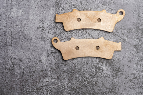 新的玫瑰金色金属摩托车双刹车片与ferdo在灰色的表面图片下载