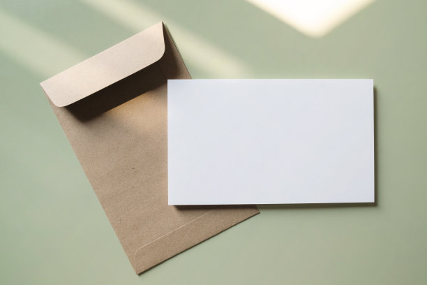 白色空白问候或邀请卡和绿色背景的信封。模拟演示。图片下载