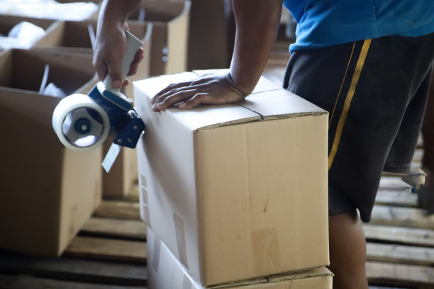 用硬纸板包装商品的人图片下载