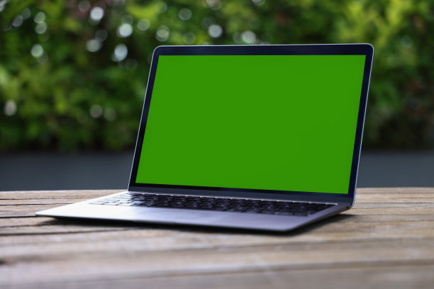 绿屏笔记本电脑模型站在咖啡馆的桌子上图片下载