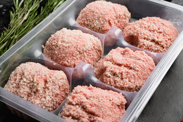 塑料包装与肉和肉丸，在黑色的深色石桌背景图片下载