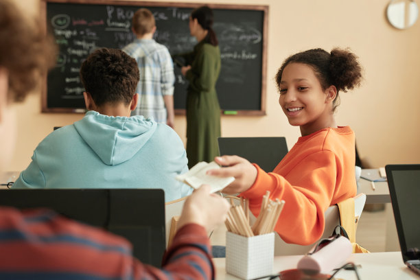 微笑的少女在课堂上给朋友递纸条图片下载