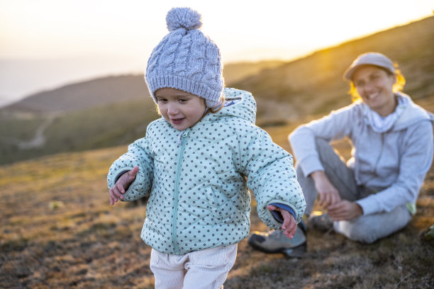 日落时分，妈妈带着女儿在大自然中远足。图片下载