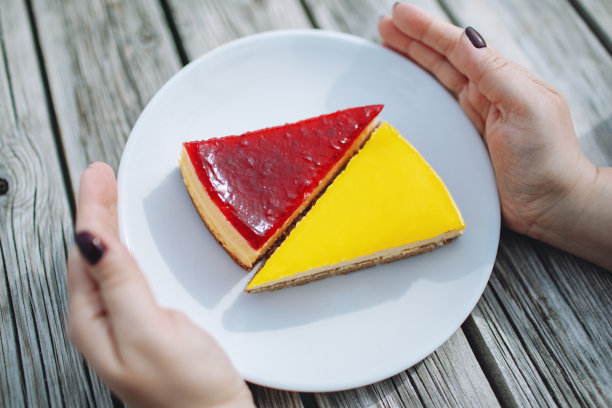 女人端着一盘柠檬草莓芝士蛋糕图片下载