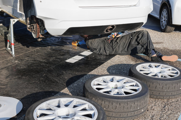 机械师躺在一辆大型巡回赛赛车下修理汽车的悬架图片下载