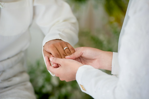 穿着白色套间的穆斯林新郎握着穆斯林新娘的手指。概念的婚礼卡背景，海报，邀请卡图片下载